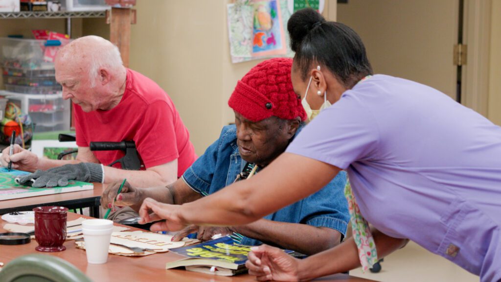 A nurse assists residents at a skilled nursing facility in an activity
