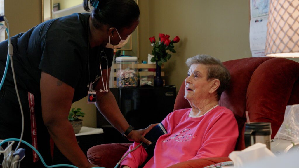 A nurse assists a woman at a skilled nursing facility respite care